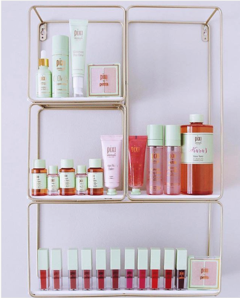 A photo of several shelves full of Pixi Beauty products.