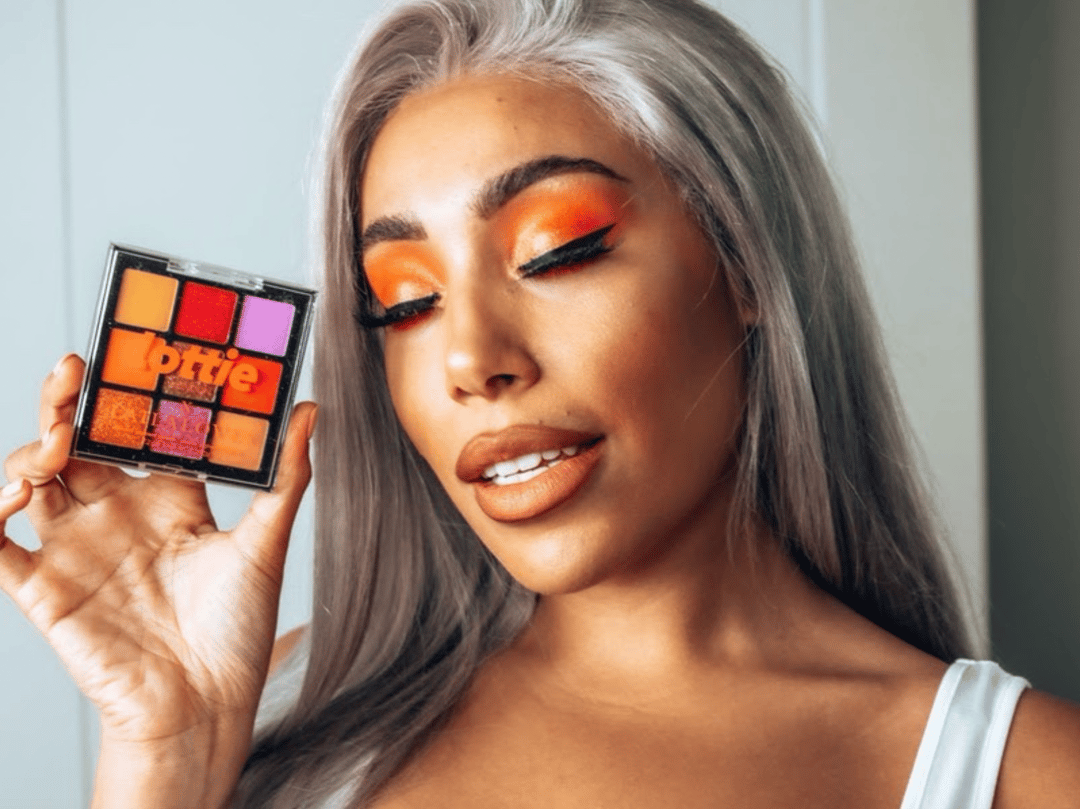 U.K. beauty influencer Laila Swann (@lailaloves) holds one of her Lottie London neon eyeshadow palettes.