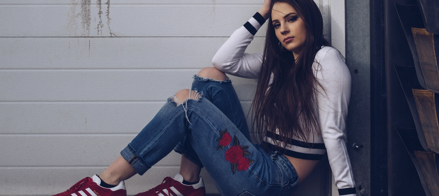 A fashion influencer poses next to a white wall, by Kalea Morgan.