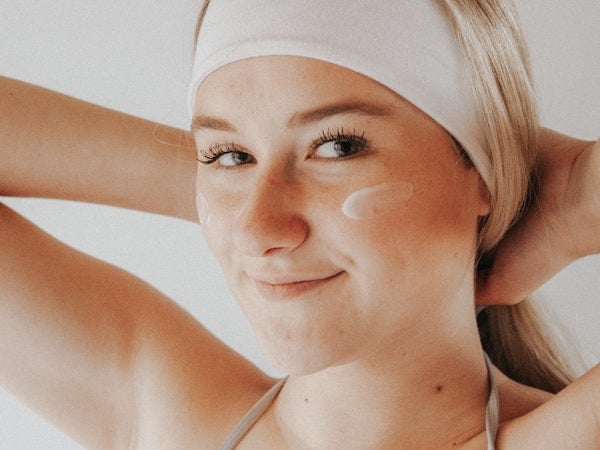 A close-up of a skincare influencer wearing sunscreen, by Cheyenne Doig via Unsplash.