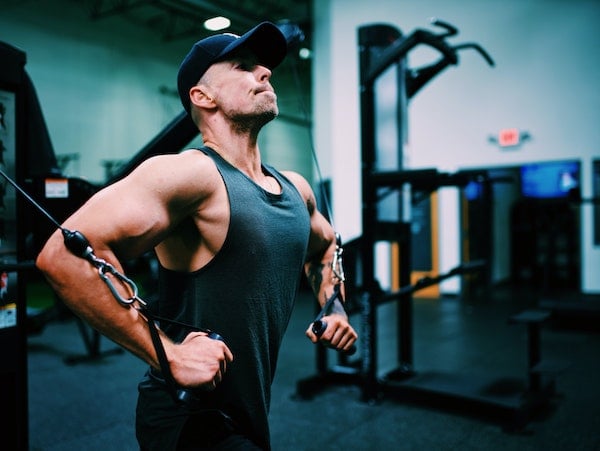 A man uses pulley weights in the gym