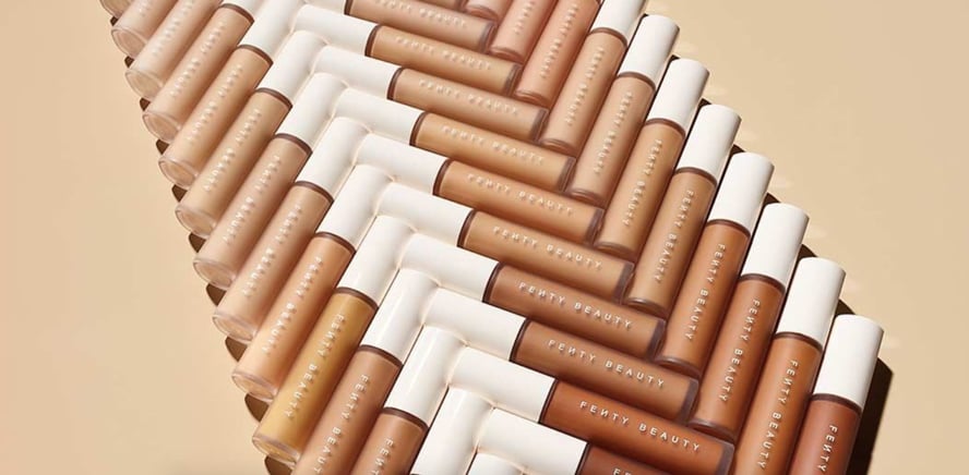 Various Shades of Fenty Beauty’s Pro Filt’r Instant Retouch Concealer arranged against a tan background.