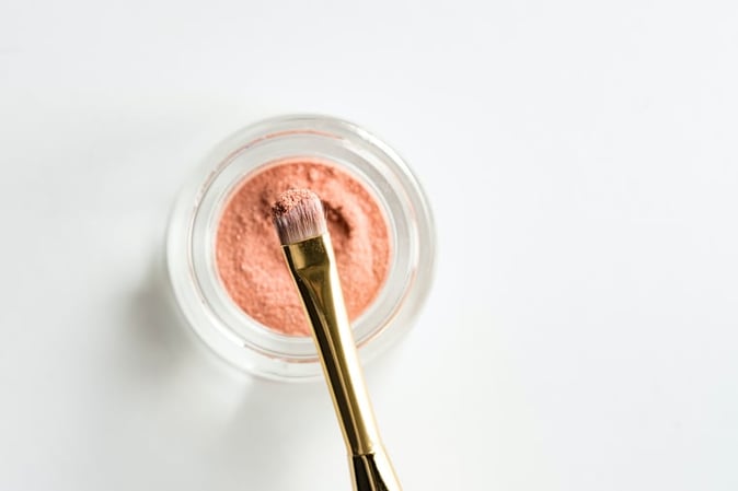 Makeup brush dipping into pomade marketing