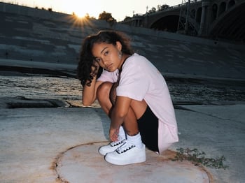 A gen z influencer wearing white sneakers, by Mike Von.