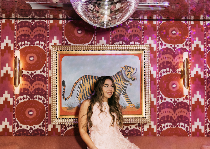 Lauryn Hock poses in front of tiger portrait