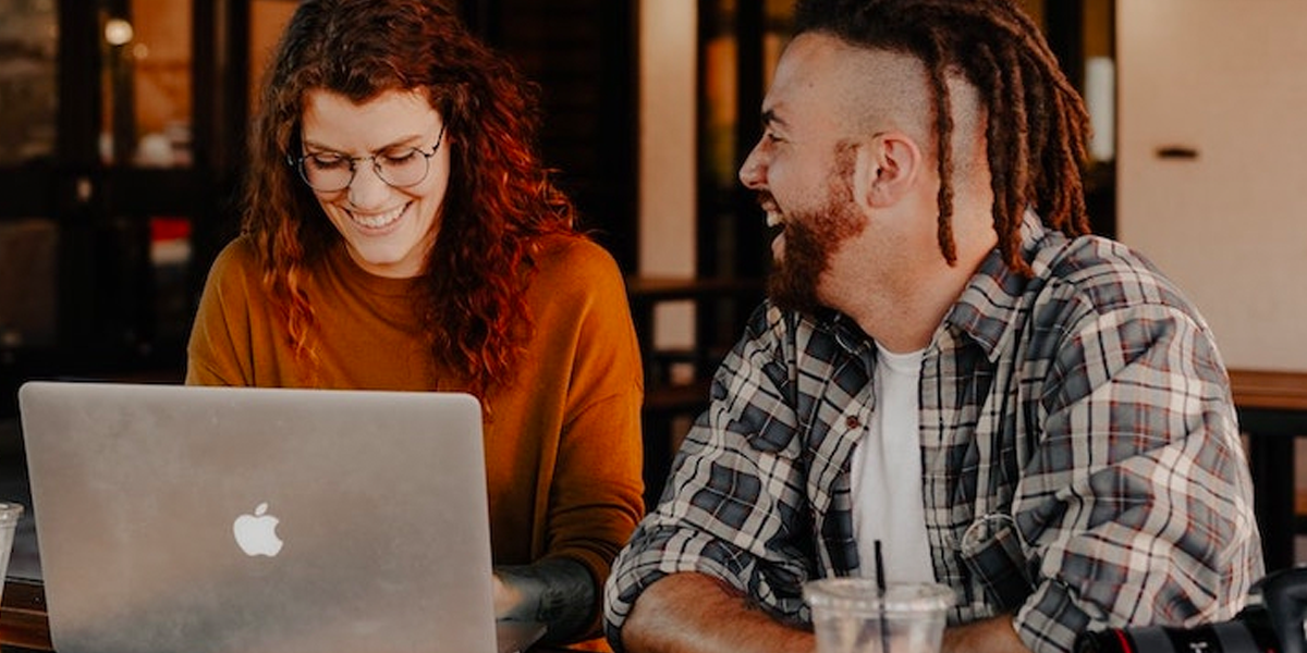 Two influencer marketing professionals working on a laptop, by Brook Cagle. 