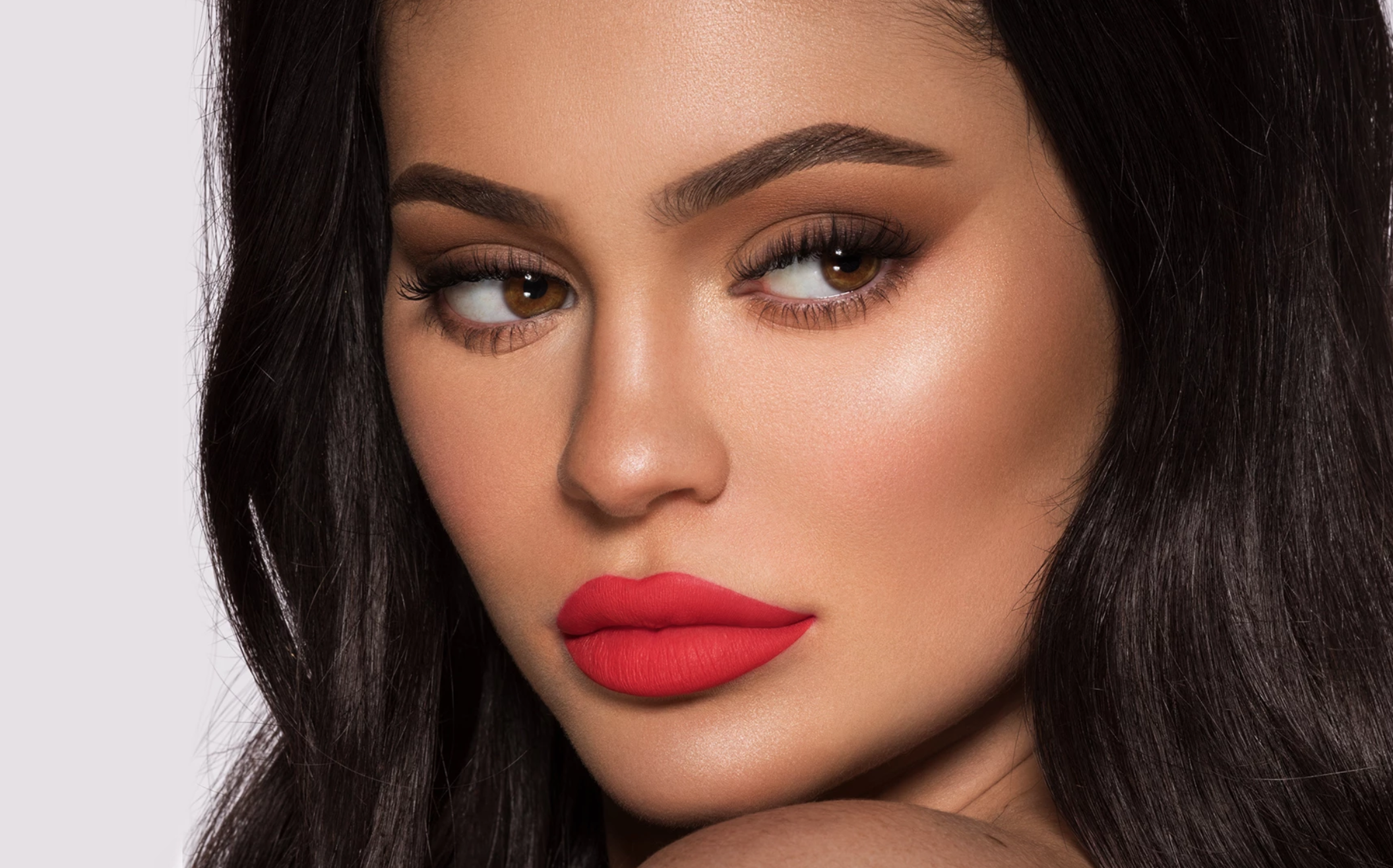 A close-up photograph of Kylie Jenner wearing products from her namesake Kylie Cosmetics brand.