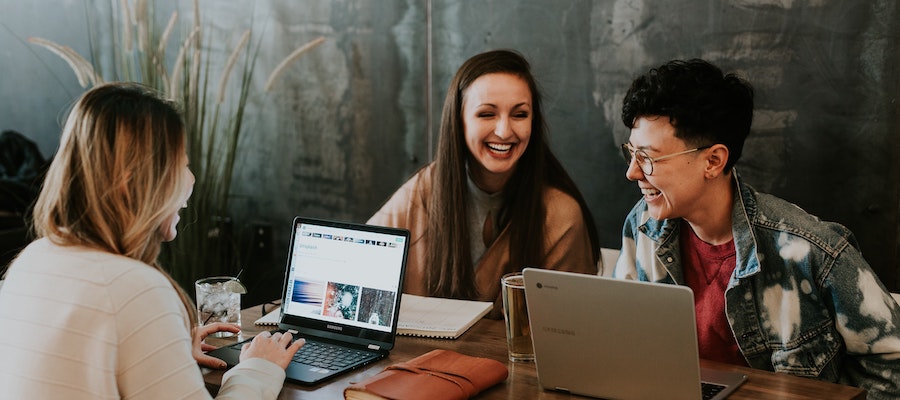 Three influencer marketing managers working at a cafe, by Brooke Cagle. 