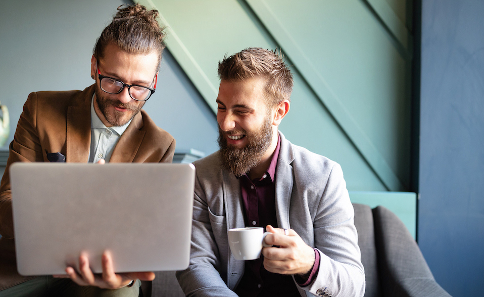 cheerful-businessmen-using-laptop-at-the-meeting-LC9BZUS