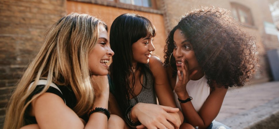 Three women chat outside a building.