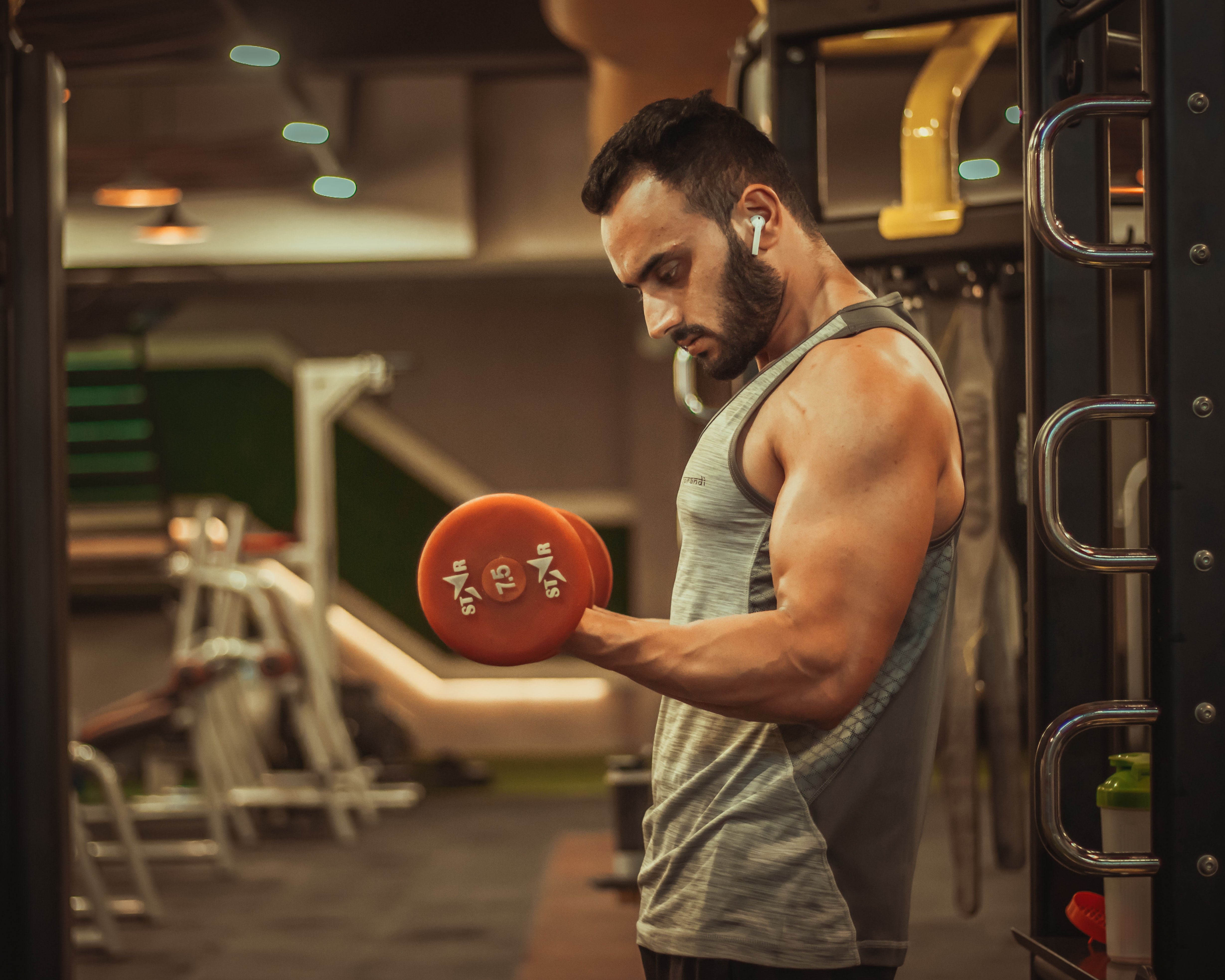 A man lifts weights wearing fitness clothes